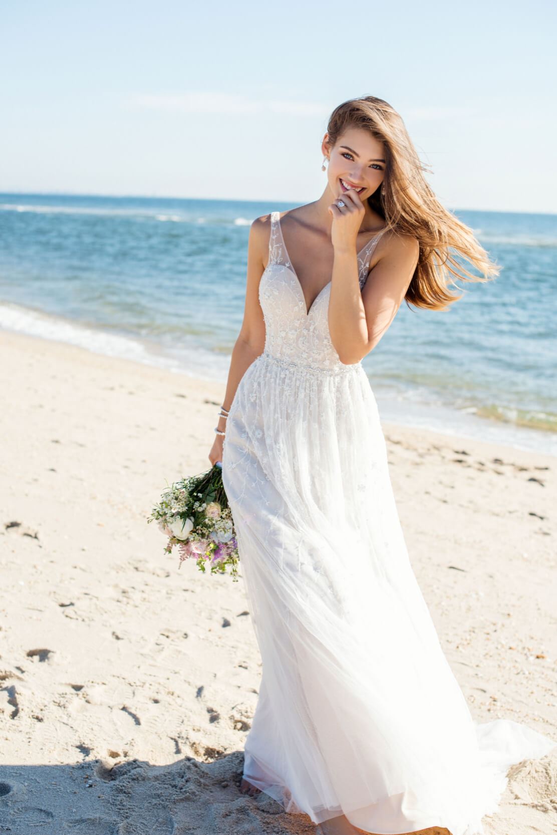 Brunette bride wearing flowy wedding dress on the beach